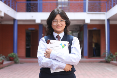 Kathford student Salomi on campus premise with books in hand