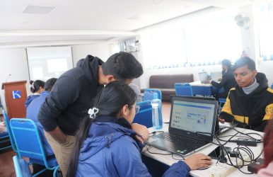 Mentor guiding students in a Canva workshop