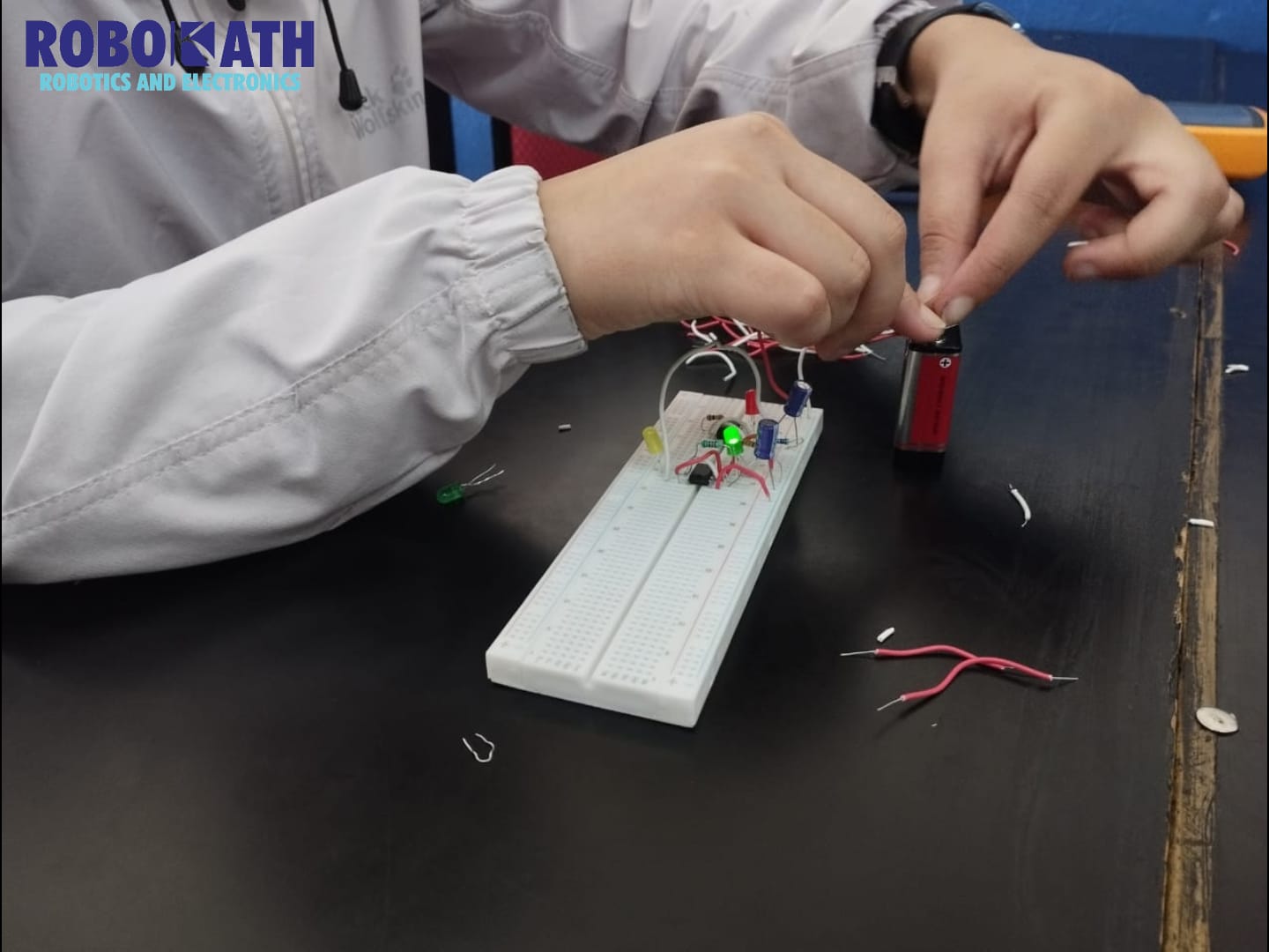 Student creating a electrical circuit using breadboard , resistors, battery, capacitor inductor