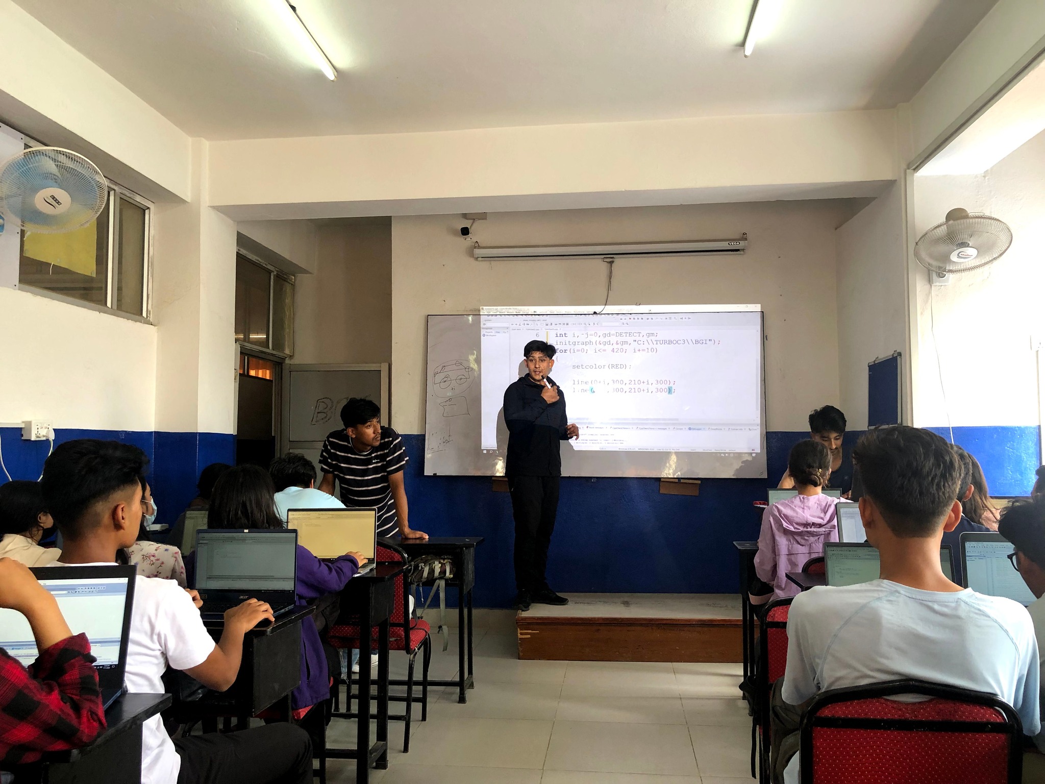 Instructor demonstrating techniques in C-based computer graphics to participants