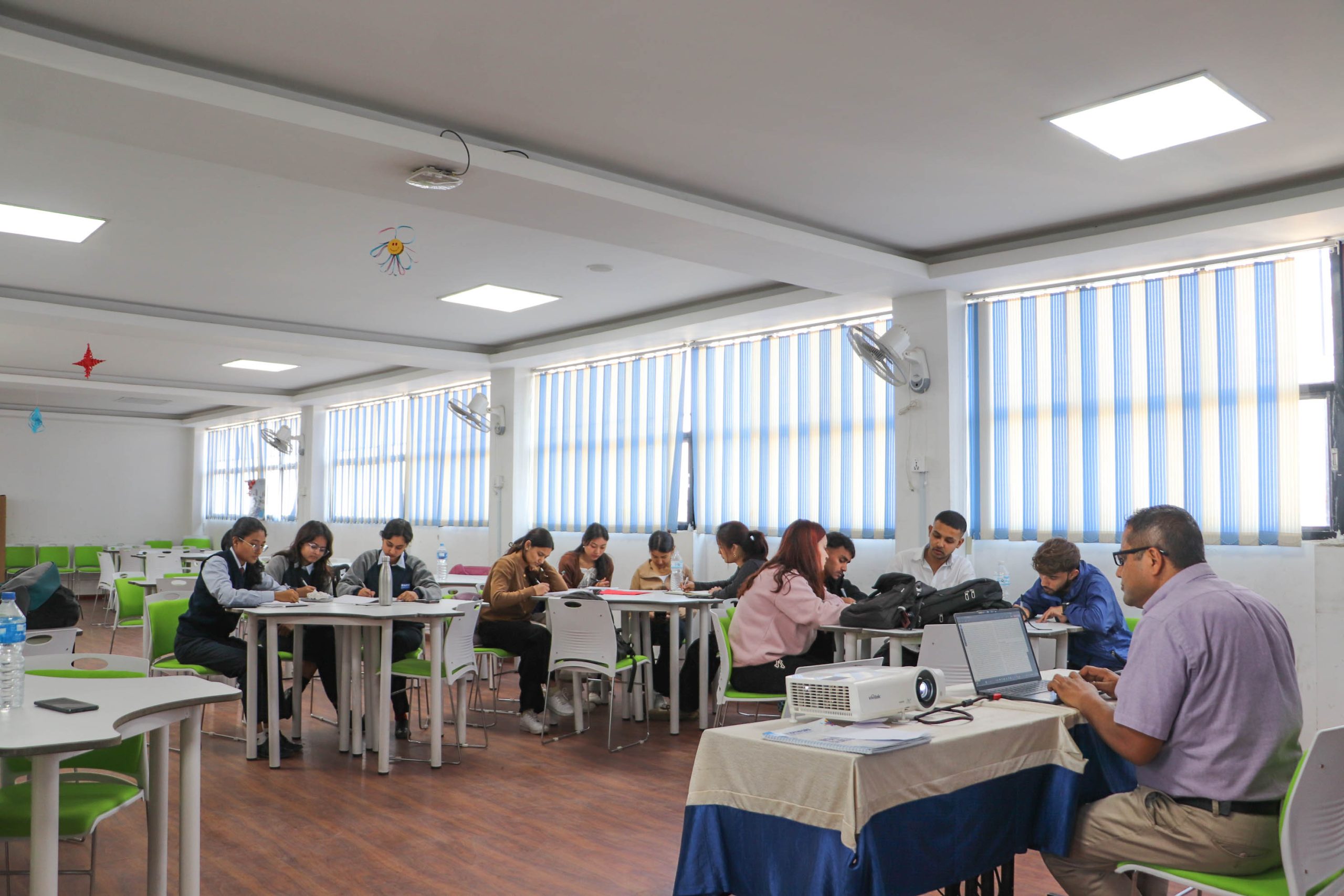 Students working on business writing tasks during a classroom workshop session.