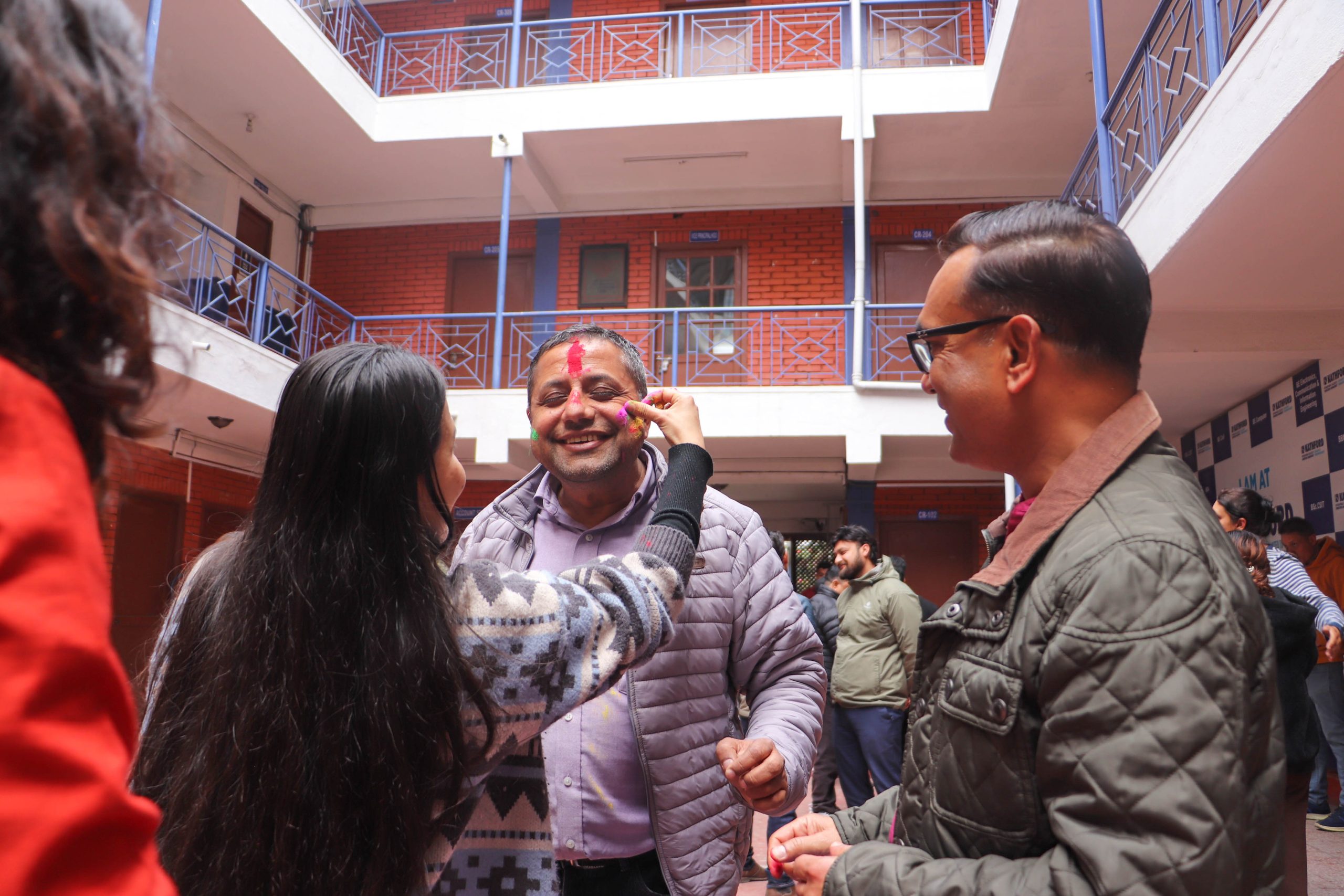 Applying Holi colors to the principal during Holi Celebration