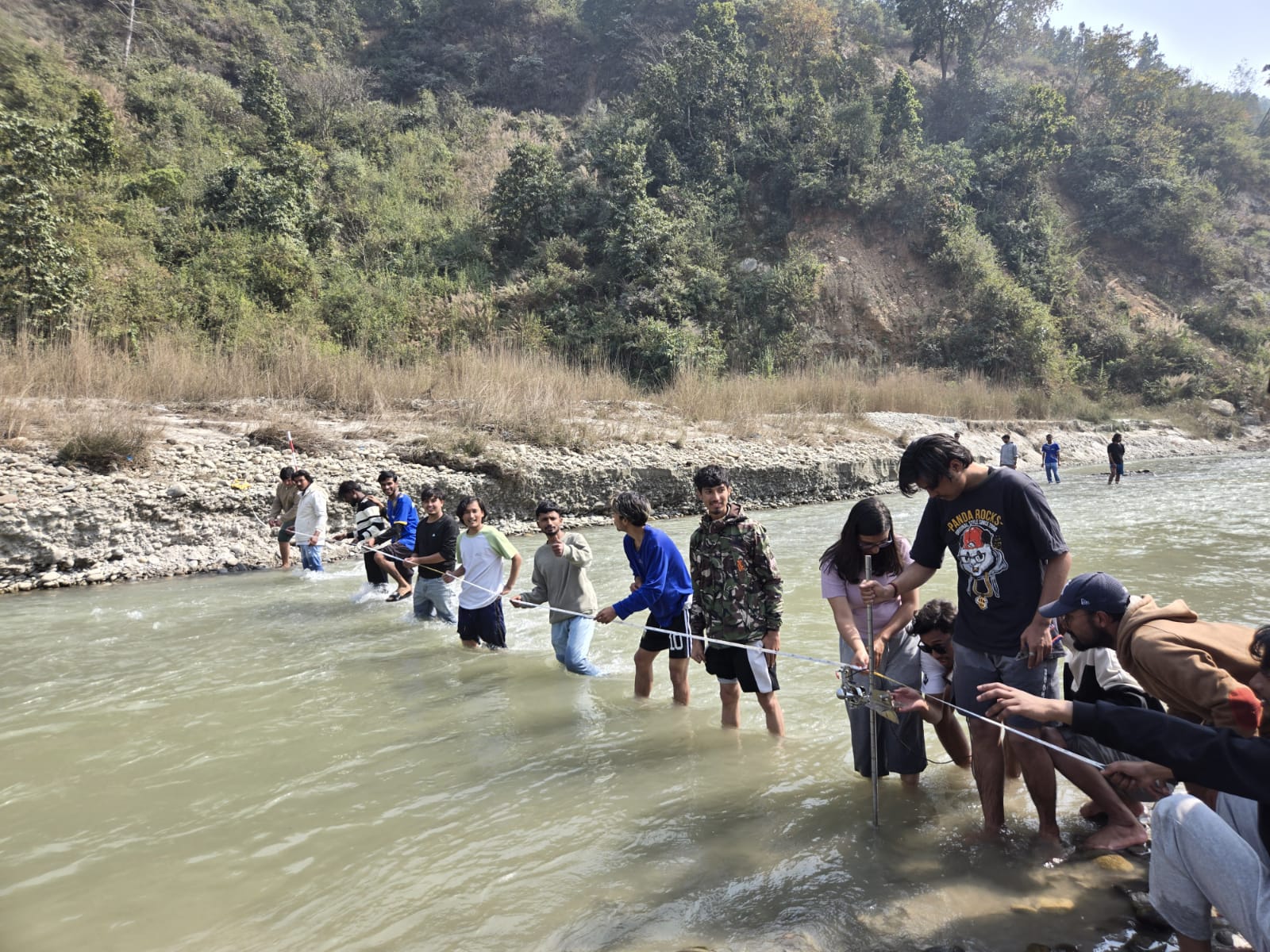 Students measuring river discharge in a stream.