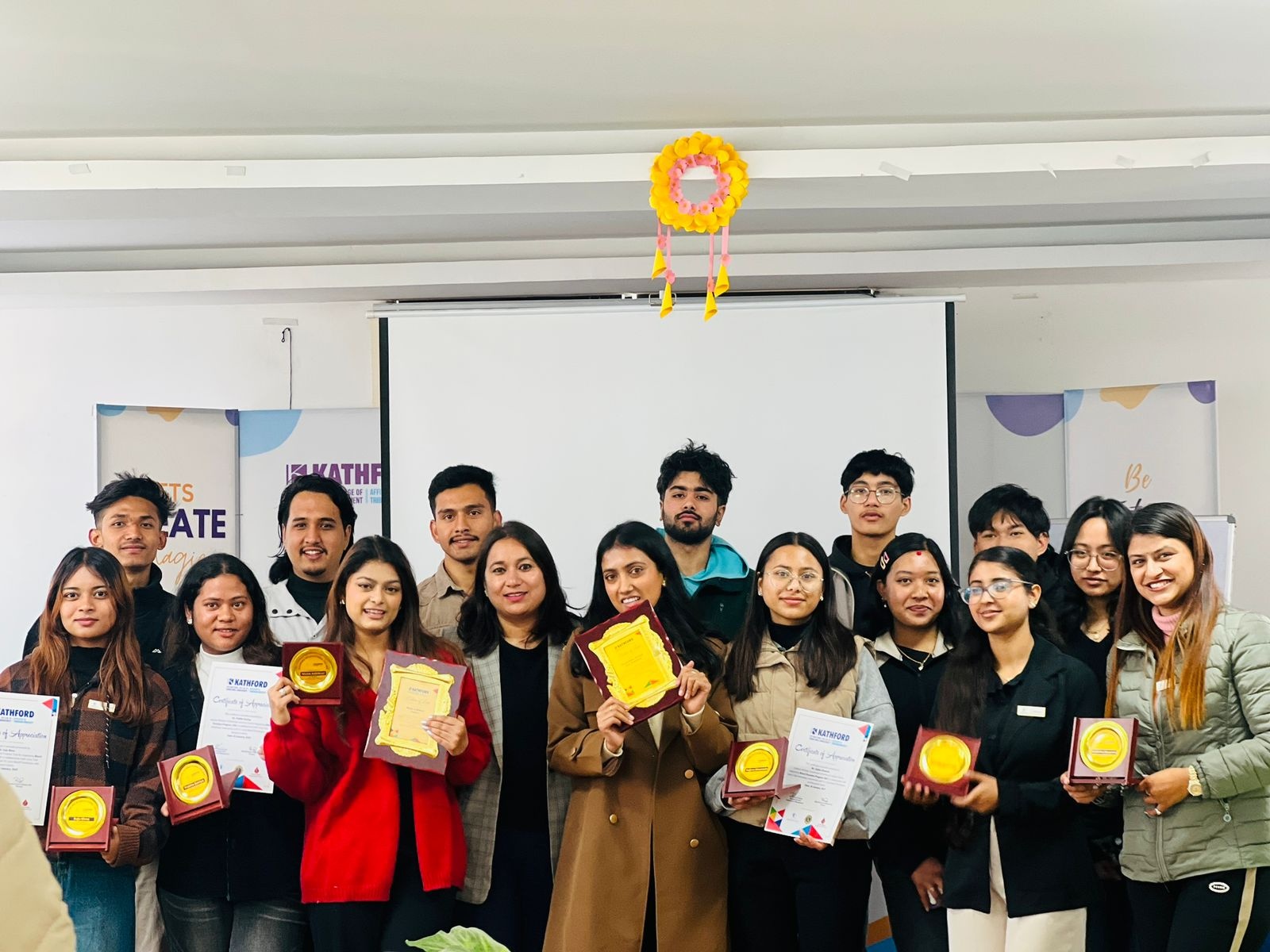 Students posing with certificates and token of love during the KPLC, KSEC, and KCC Club oath-taking ceremony.