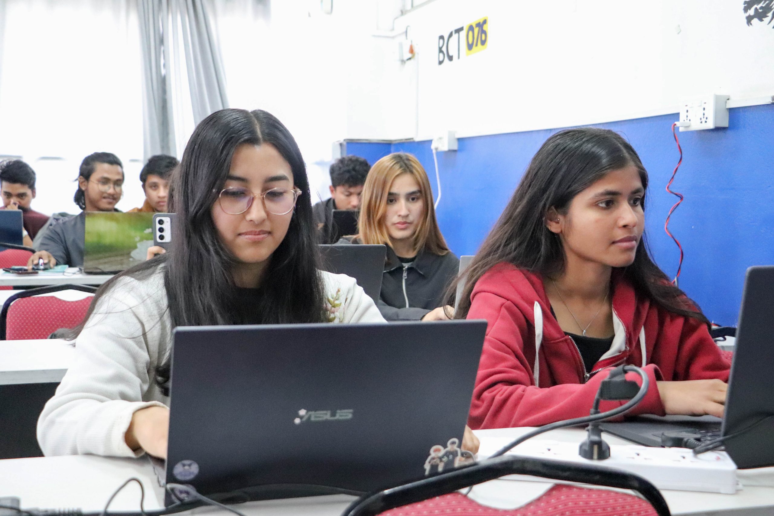 BCT first semester students attending a Python workshop using laptops in a classroom.