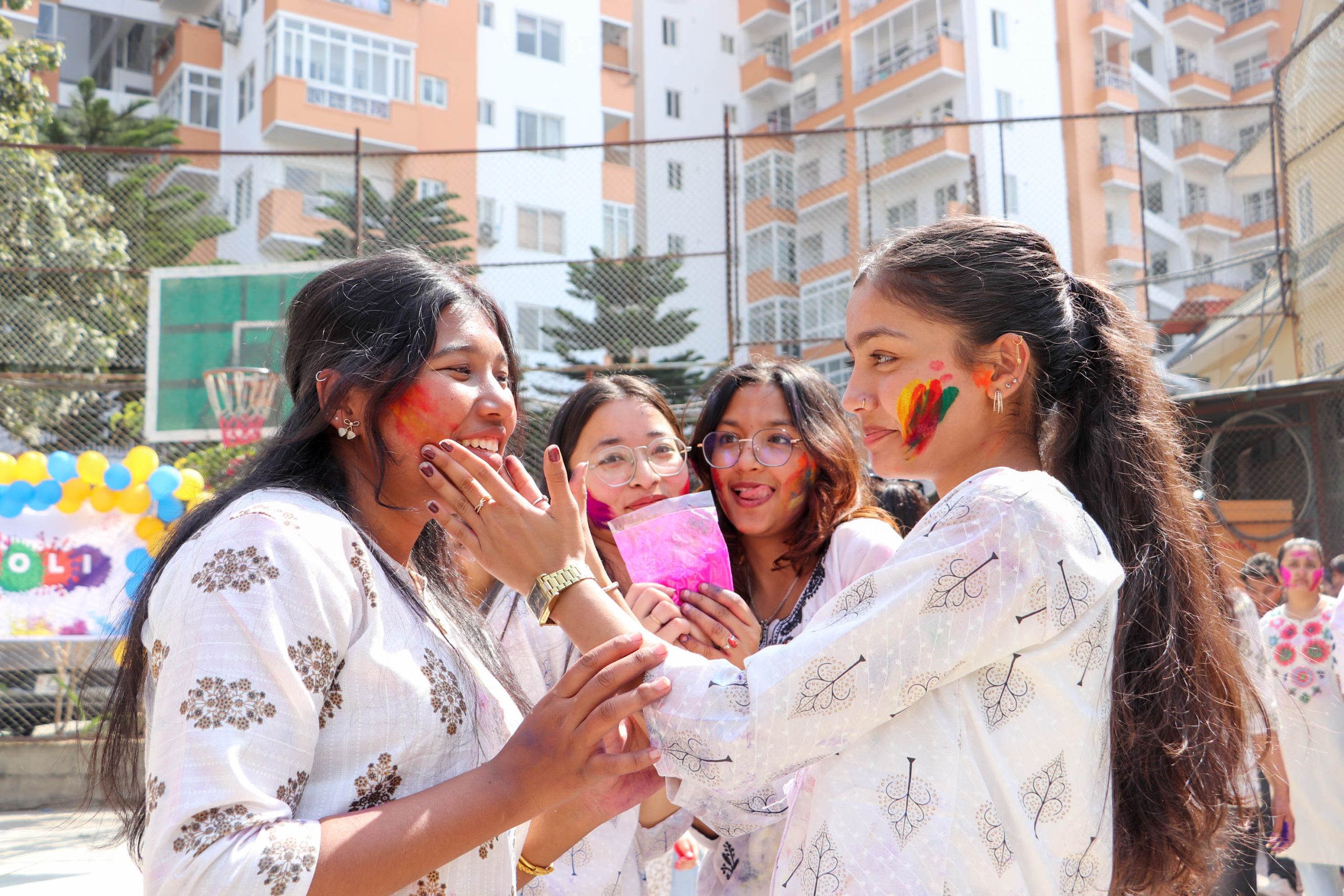 Students applying Holi colors to each other during the Holi celebration