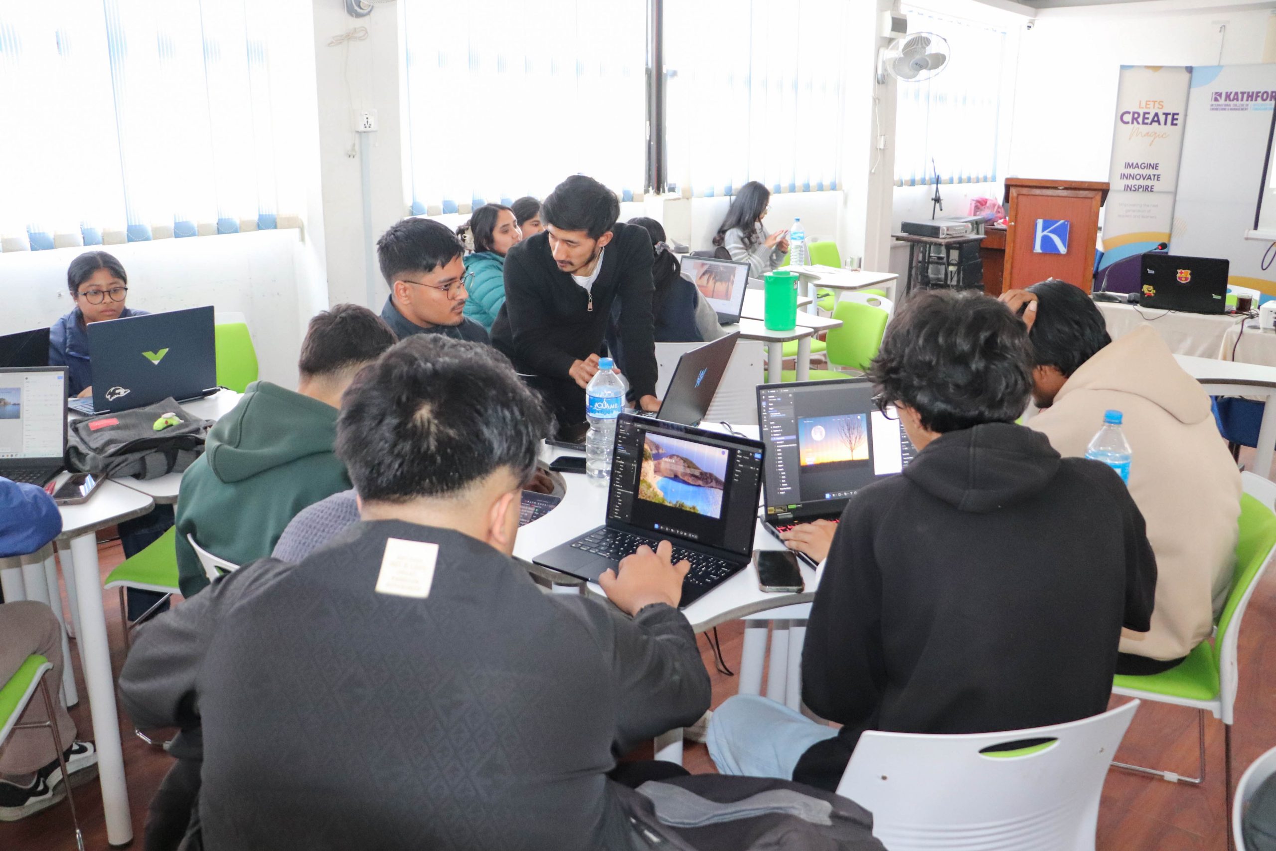 Students attending a UI/UX training session with laptops while a guest instructor guides them.